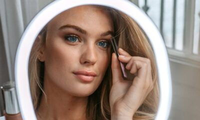 Ung kvinna framför makeup-spegel