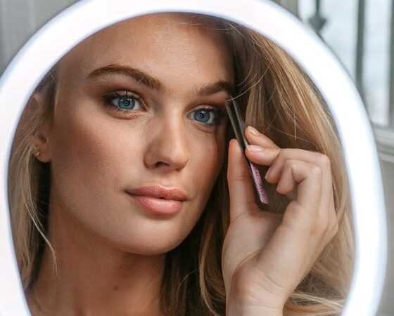 Ung kvinna framför makeup-spegel