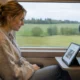 Kvinna åker tåg och tittar på en iPad